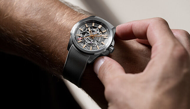 Detailed shot of NORQAIN skeleton dial watch with black rubber strap – modern Swiss engineering