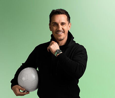 Gary Neville wearing a NORQAIN men's sports watch with green rubber strap, holding a football against a mint green background