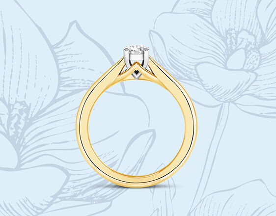 Yellow gold solitaire engagement ring with hidden diamond detail, set against floral sketch background.