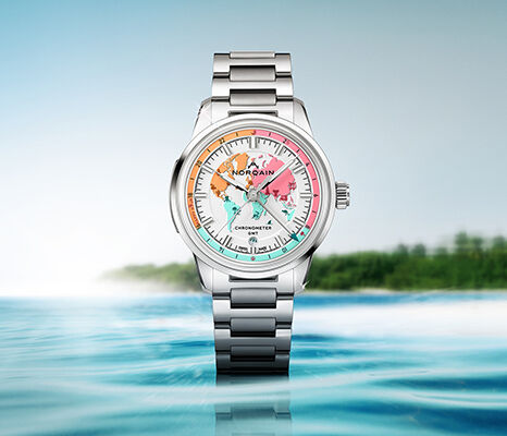 NORQAIN watch with a colourful world map dial, displayed above the sea.