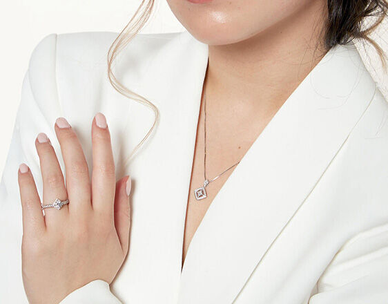 Close-up of woman wearing Northern Star Canadian diamond engagement ring and pendant, ethically sourced jewellery